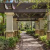 a walkway with a gazebo and trees