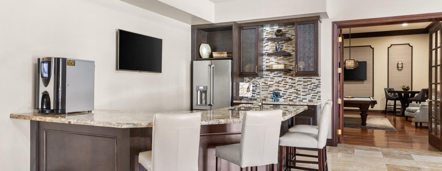 a kitchen with a bar and chairs